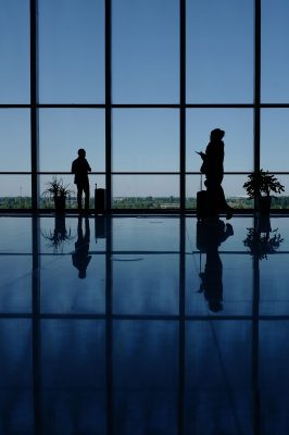 A couple of people that are standing in front of a window